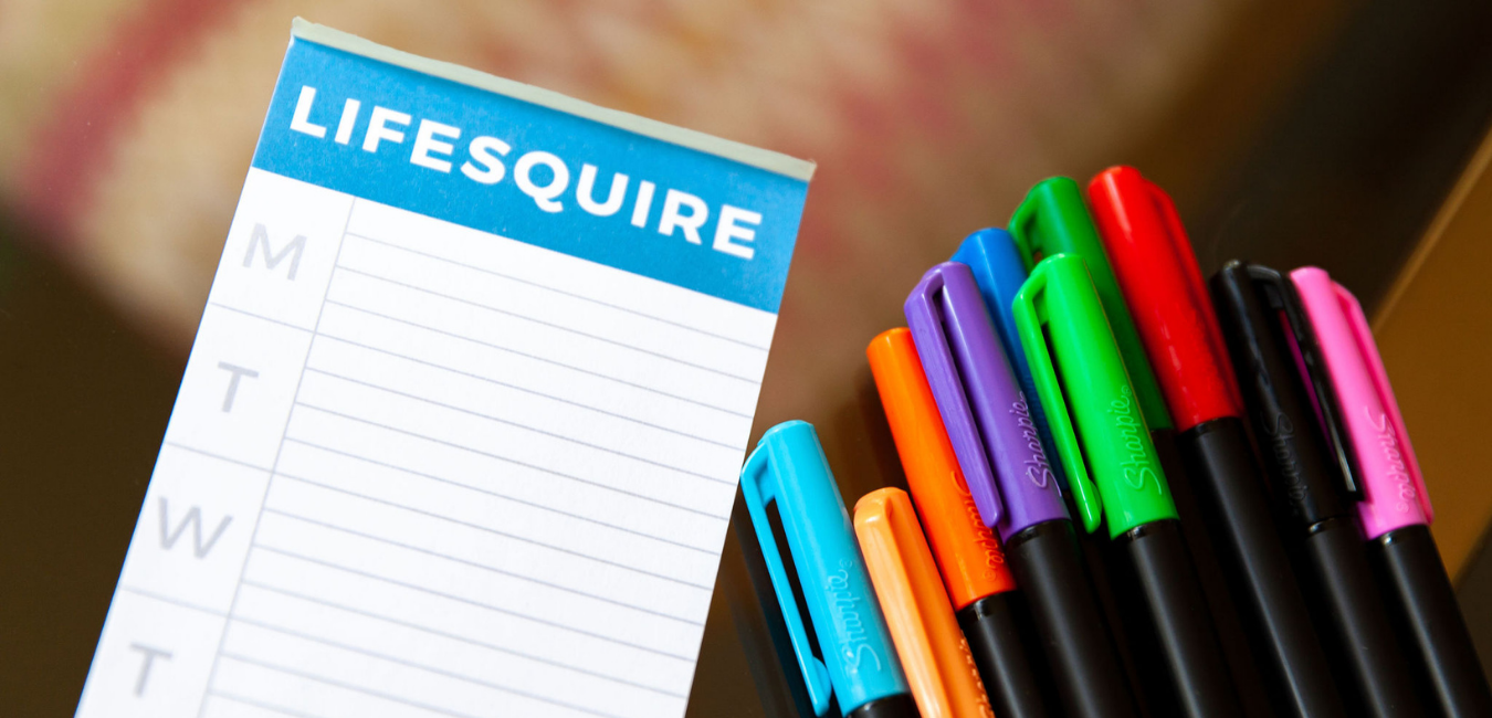 A notebook with "lifesquire" in text at the top with multi-colored sharpies to the right